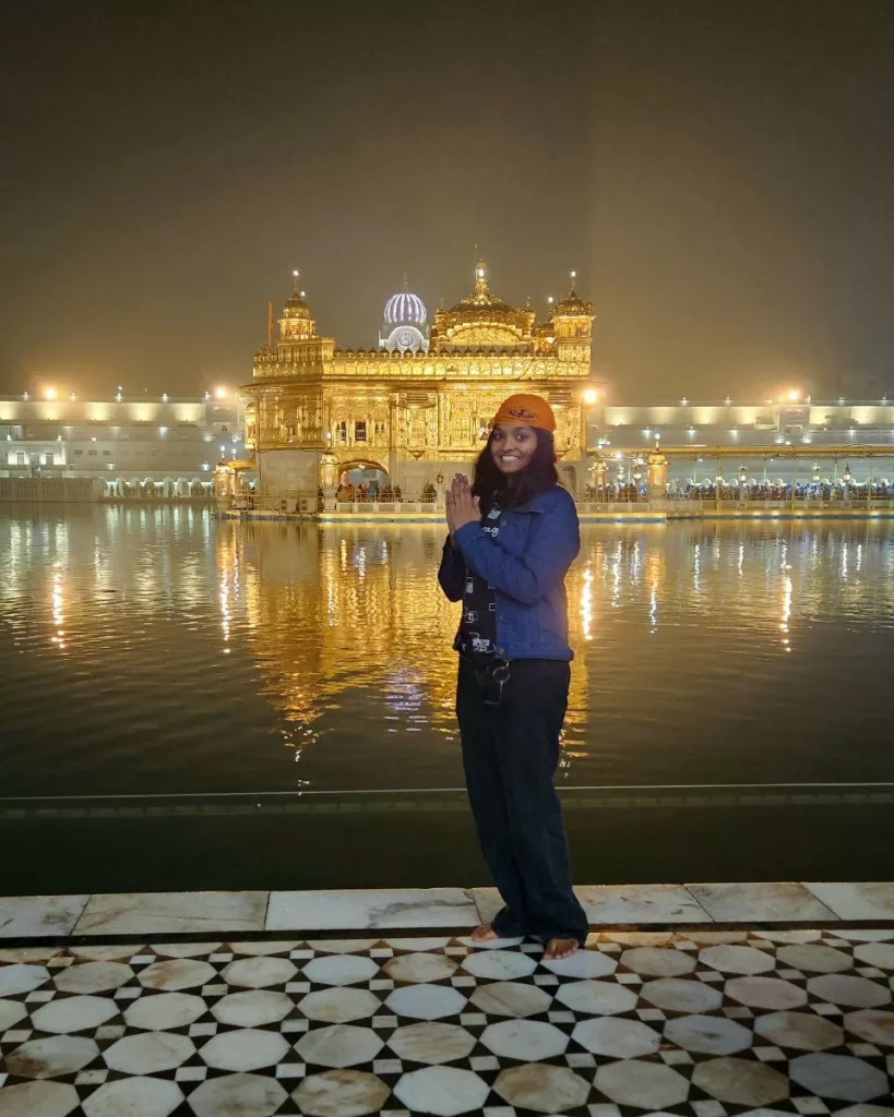 golden temple, solo traveler Shruti standing in front of golden temple