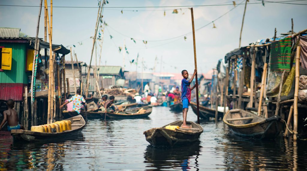 Child standing and rowing boat in Nigeria